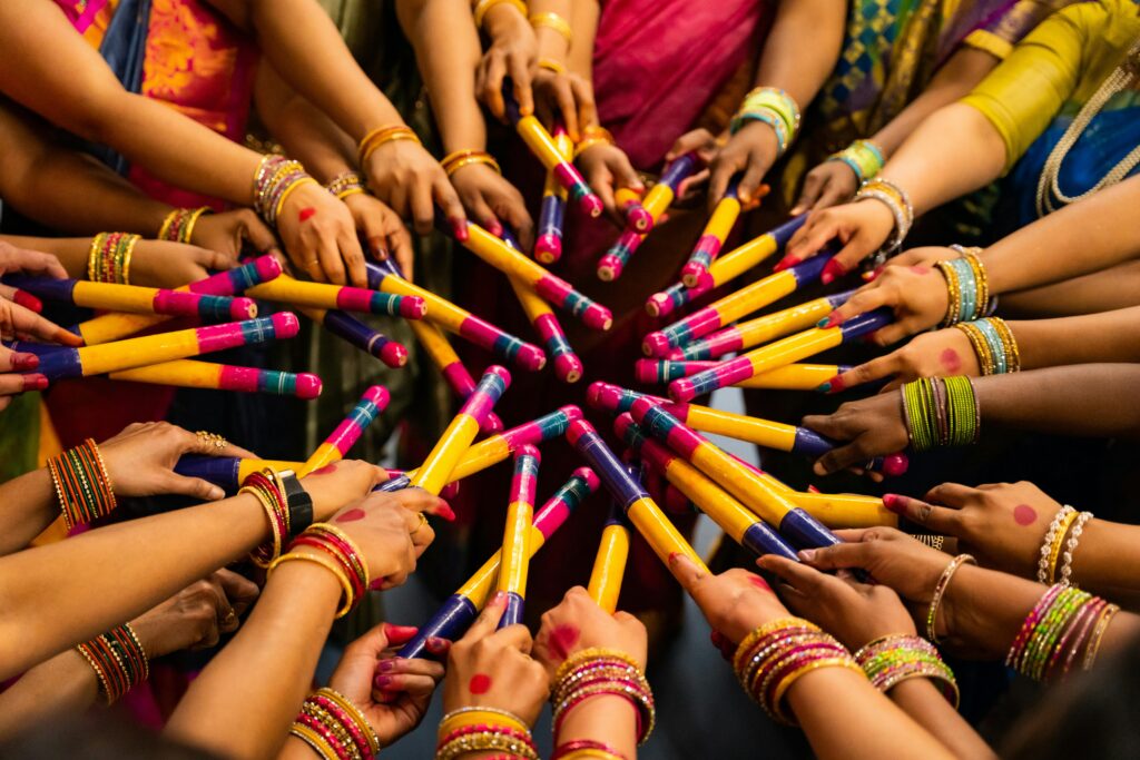 Colorful display of hands with dandiya sticks celebrating Navratri festival, showcasing Indian culture.