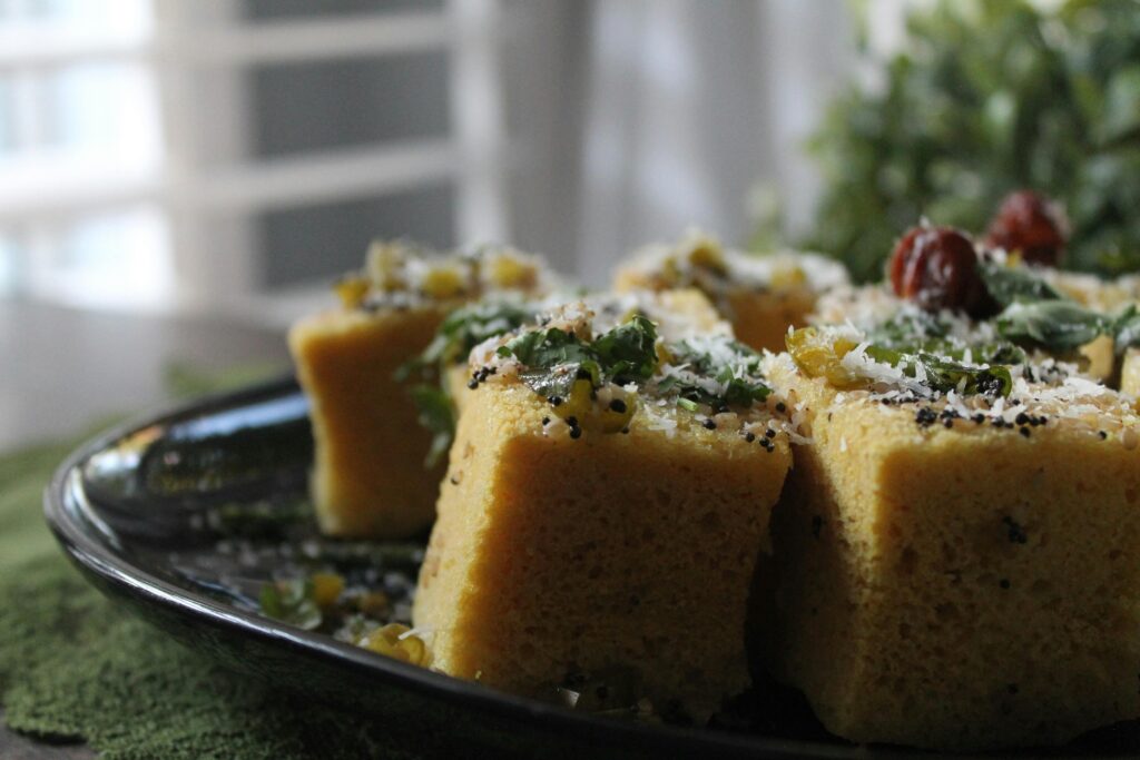 Delicious cornbread topped with herbs and cheese on a ceramic plate, showcasing food styling.